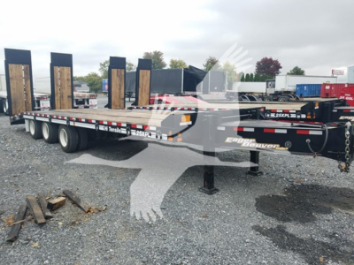 Trailer showing flatbed with dual axle and tall wooden boards on uprights, Eager Beaver 25Xpl branding visible on frame.