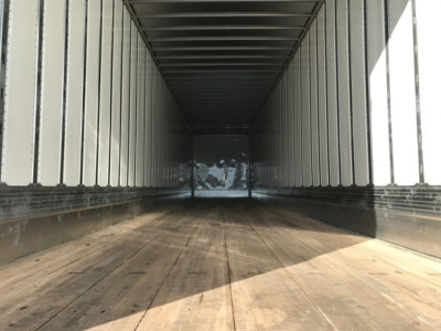 Interior of a Utility 4000Dx Trb trailer showing long empty cargo area with wooden floor and ribbed metal walls.