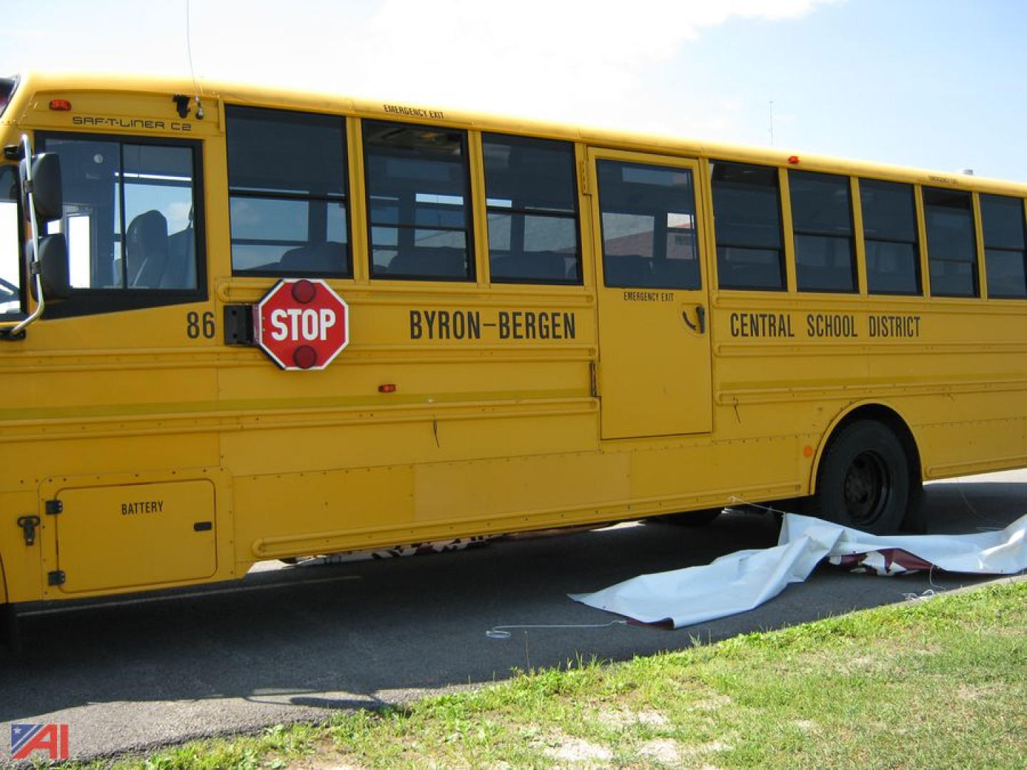 School bus side view showing 'BYRON-BERGEN CENTRAL SCHOOL DISTRICT' markings, stop sign, bus number 86, and windows along the yellow Freightliner C2 body.