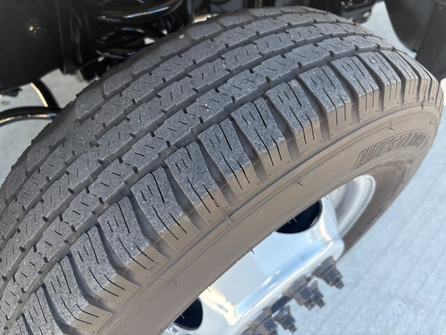 Truck wheel and tire close-up showing tread pattern and disk brake area; no legible labels visible in this view.