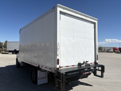 Box truck rear view showing large white cargo box, Ford E350, rear doors, bumper, taillights, and black hitch with safety chains. No visible text besides general vehicle features.