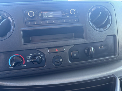 Ford E-350 dashboard showing radio unit, HVAC controls, and circular vents.