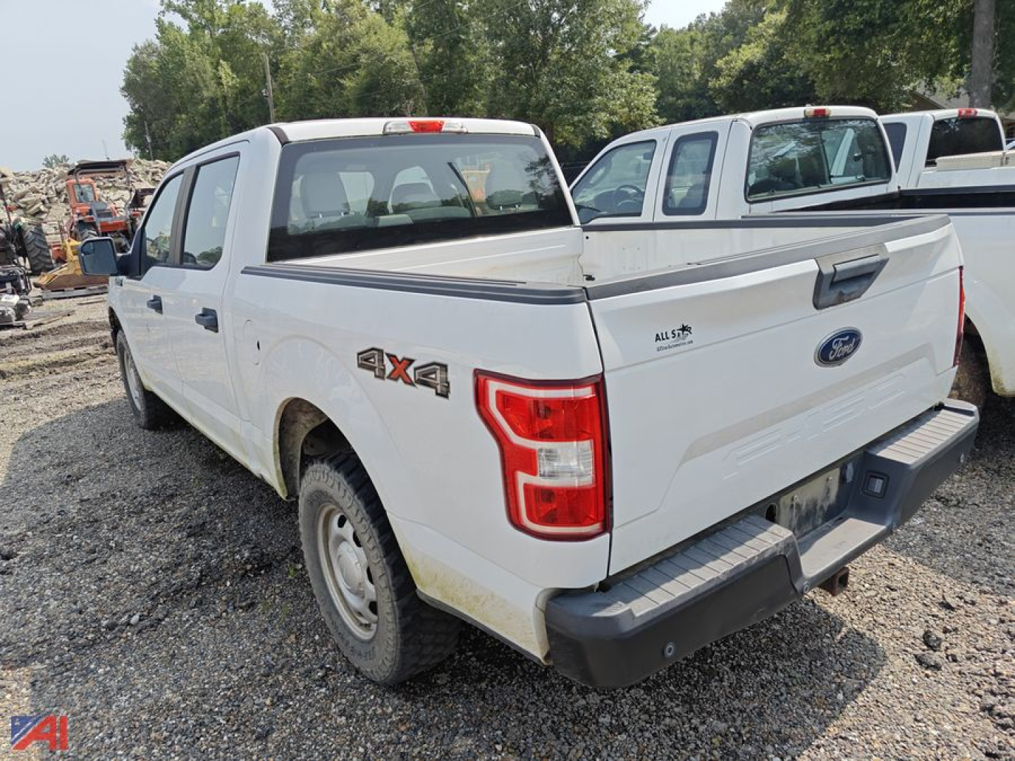 Ford F-150 pickup truck with 4x4 badge, white crew cab, rear view showing tailgate and bed, used vehicle.