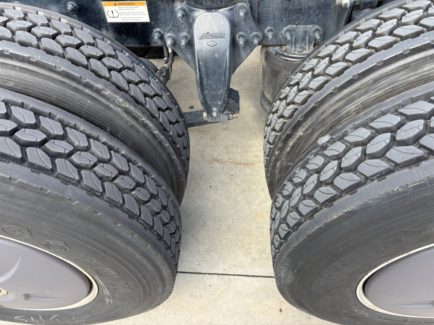 Dual rear tires of a Freightliner tractor showing tandem axle and hitch assembly.