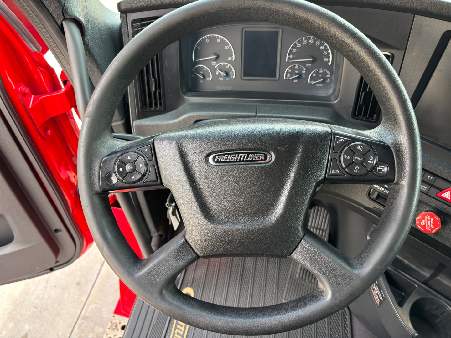 Steering wheel and dashboard of Freightliner PT126064ST truck showing steering wheel with Freightliner emblem and instrument cluster.