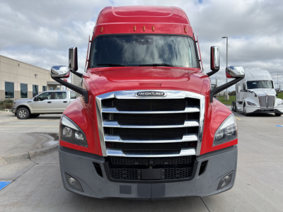 Front view of a red Freightliner PT126064ST sleeper cab truck with large chrome grille and bumper, dual mirrors, headlights, and fog lights visible.