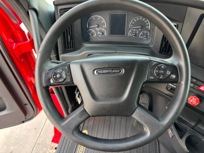 Steering wheel and dashboard of Freightliner PT126064ST truck showing steering wheel with Freightliner emblem and instrument cluster.