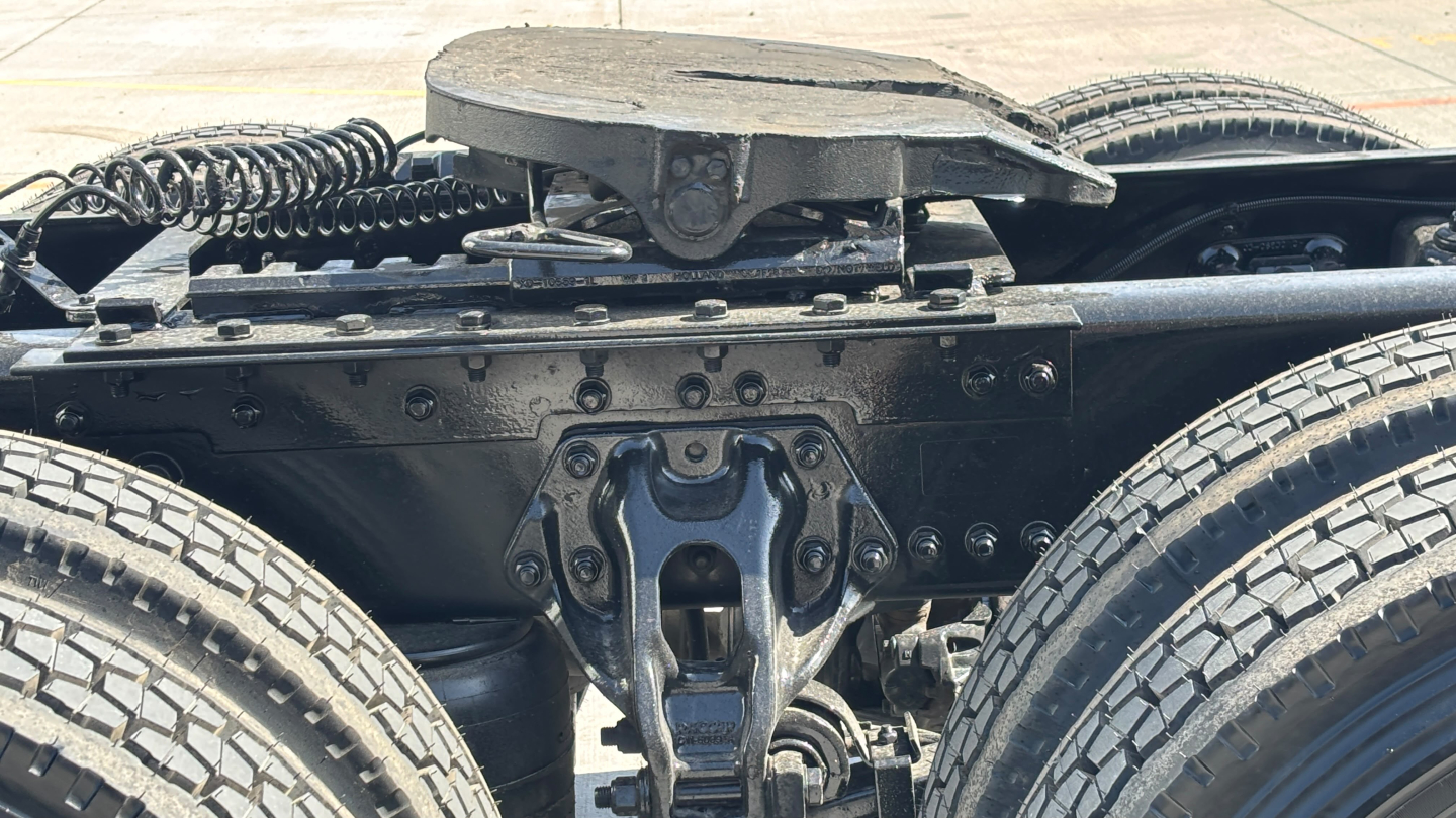 Kenworth truck chassis view showing fifth wheel and suspension at rear, dual rear wheels and drivetrain components