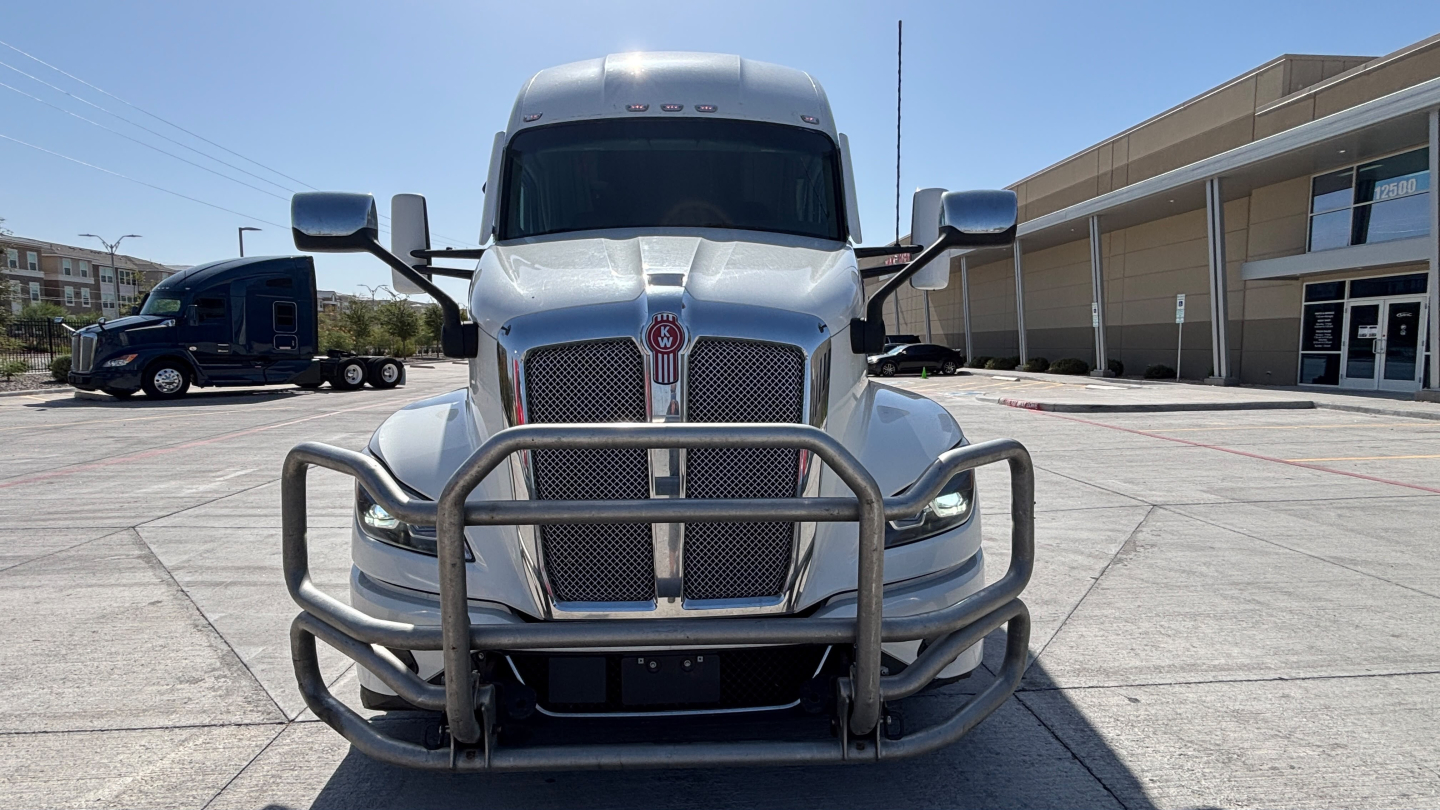 Kenworth T680 conventional sleeper truck front view with grille guard and chrome mirrors, silver exterior.