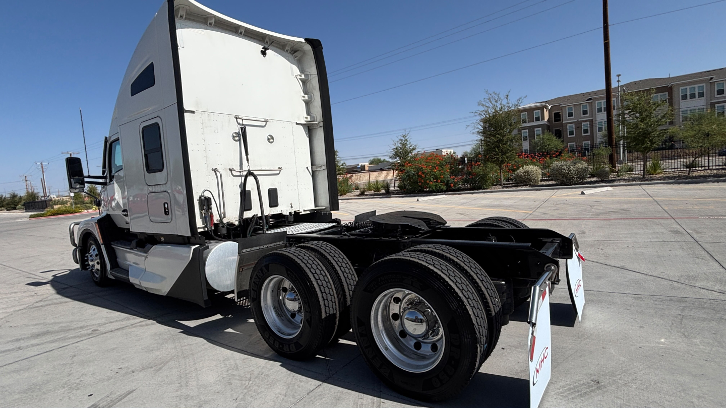Kenworth T680 tractor, side/back view showing dual rear axles, fifth wheel, and cab with sleeper, white exterior.