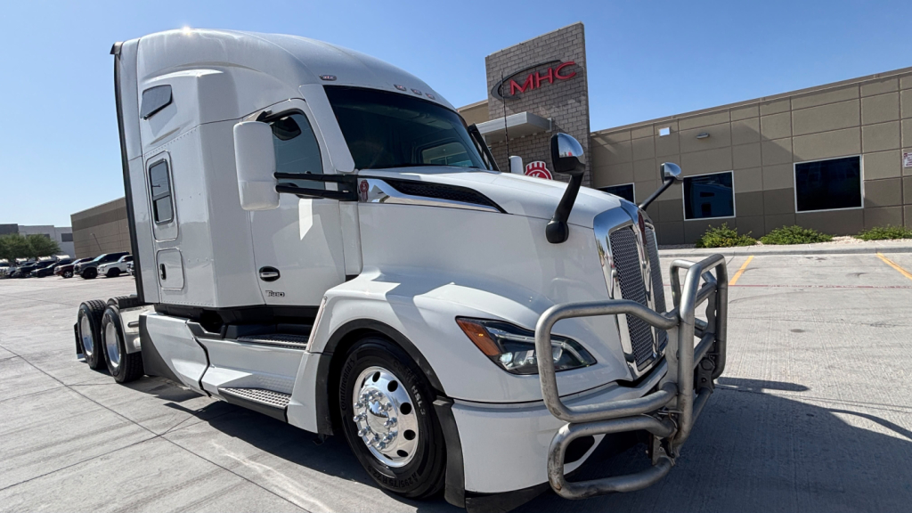 Kenworth T680 sleeper cab truck showing front grille guard and chrome bumper in a dealership lot