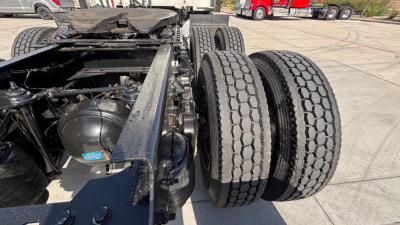 Kenworth T680 chassis and rear dual-axle wheels showing suspension and frame with black components and tires in view.