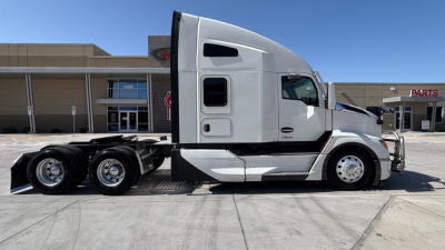 Kenworth T680 tractor side view showing sleeper cab, tandem rear axles, chrome wheels, and white exterior with side window and door details.