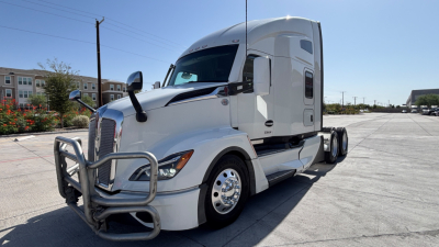 Kenworth T680 tractor in white, front grille guard, side view showing sleeper cab, dual rear axles, large mirrors.