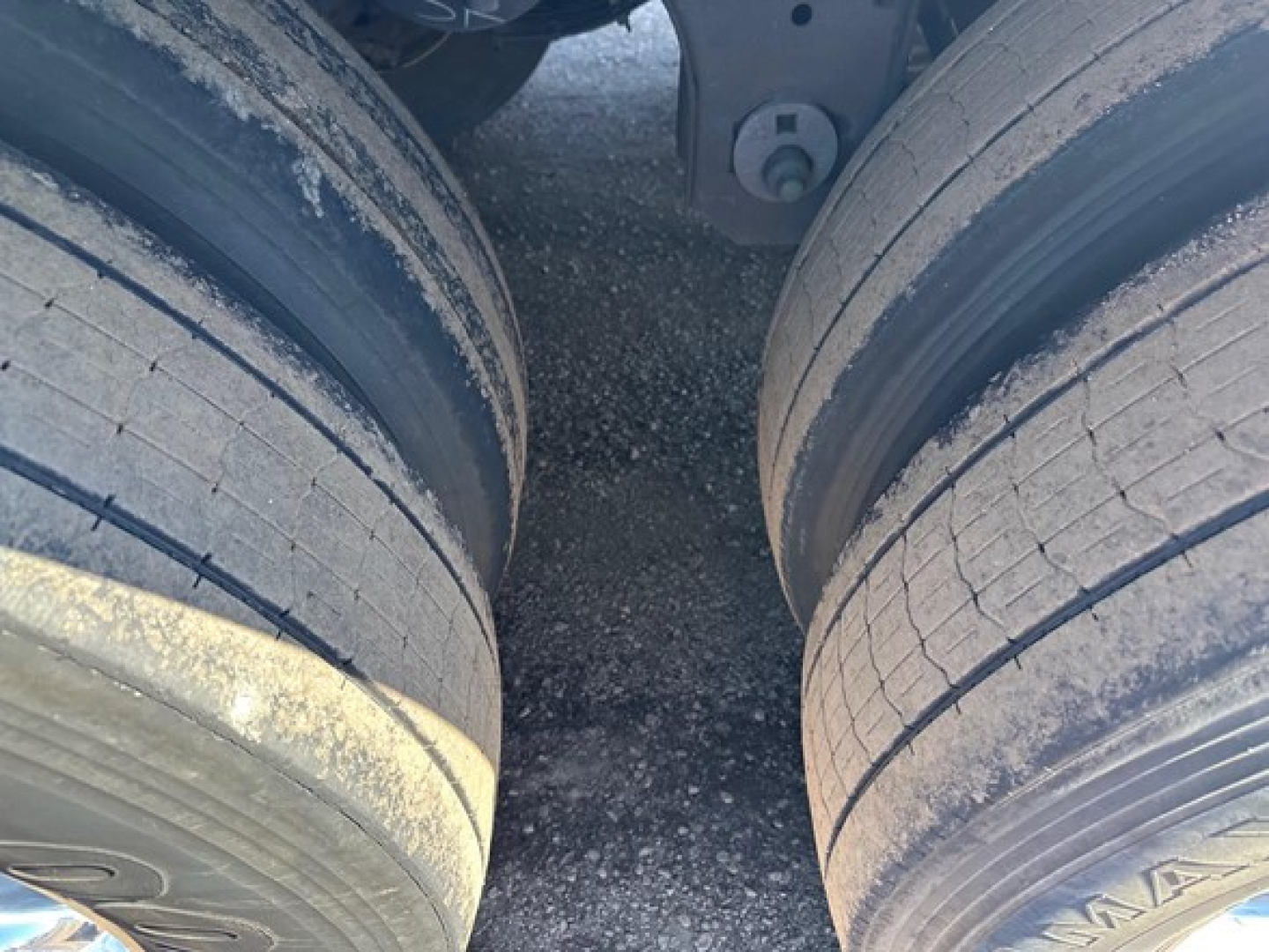 Trailer axle tires and frame showing dual rear tires and suspension near the kingpin of a 2023 Utility S-700 trailer.