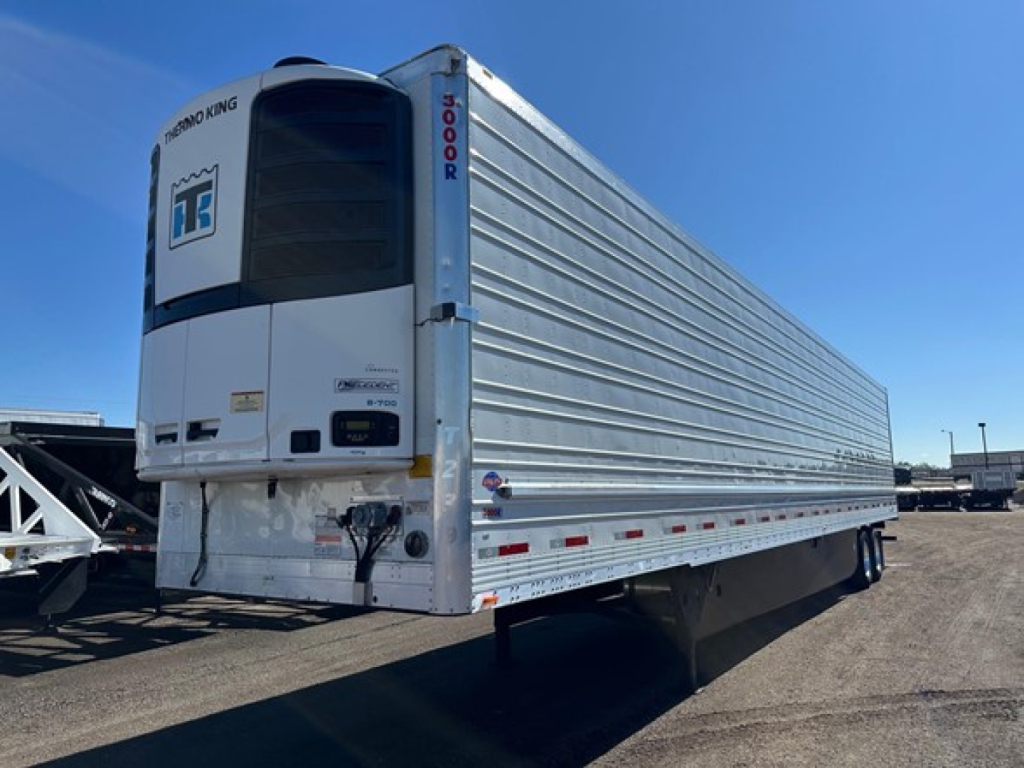 Utility S-700 reefer trailer showing rear refrigeration unit and side corrugated aluminum walls.