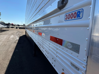 Trailer side with '3000R' logo and Utility brand sticker; horizontal ribs and rivets along aluminum side; reflective tape near midsection.