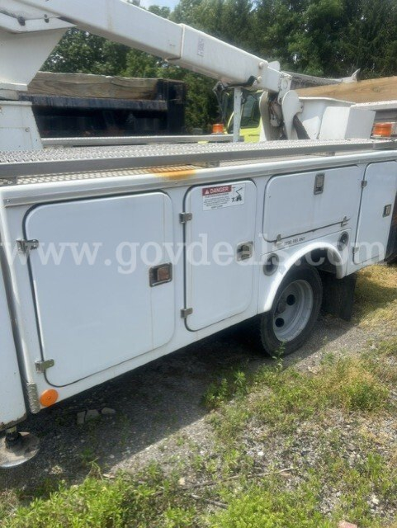 Truck utility body side view showing compartments and bucket lift arm on a 2000 Chevrolet C/K 3500 utility truck