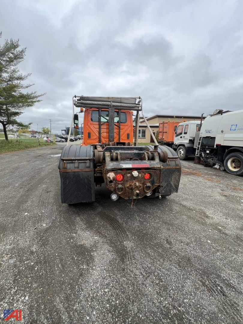 Rear view of 2012 International SA525 WorkStar 7400 roll-off truck showing towing hitch, mud flaps, and dual rear lights.