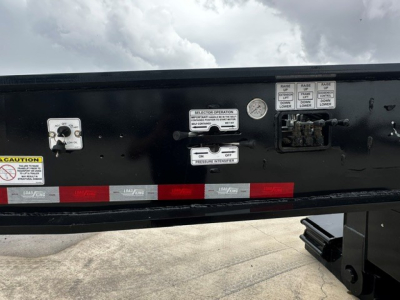 Trailer side panel showing multiple control labels and switches with caution stickers and reflective tape.