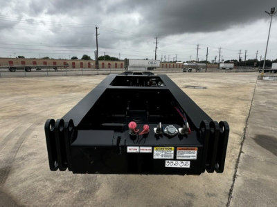 Load King lowboy trailer hitch area showing rear frame and mounting hardware with warning labels and coupler brackets.