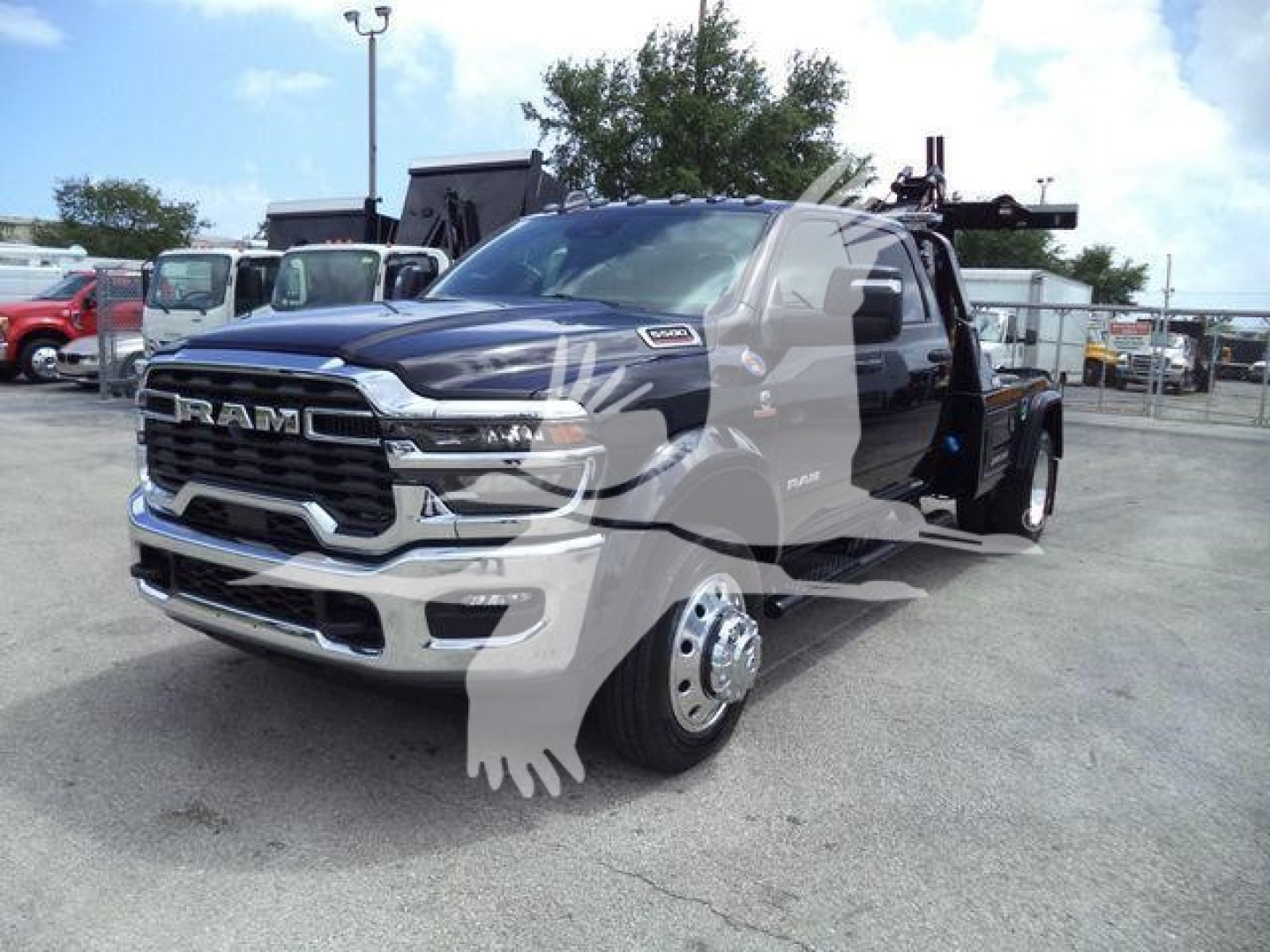 Ram 5500 heavy-duty truck front-left view with large grille, chrome bumper, dual rear wheels, and tow winch setup in a dealership lot.