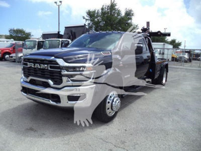 Ram 5500 heavy-duty truck front-left view with large grille, chrome bumper, dual rear wheels, and tow winch setup in a dealership lot.
