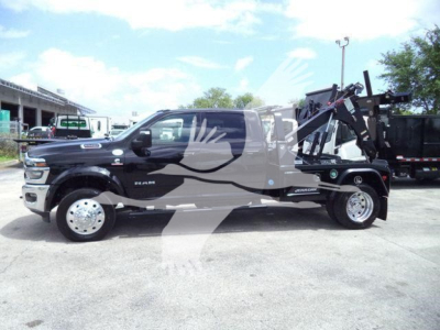 Ram 5500 Big Horn pickup with winch equipment and jeeps in background, side profile view
