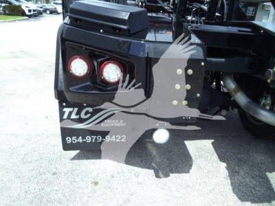 Rear of a truck showing two round taillights, bumper with TLC Truck Equipment logo, and RAM 5500 chassis. Visible text: TLC Truck Equipment, 954-979-9422.