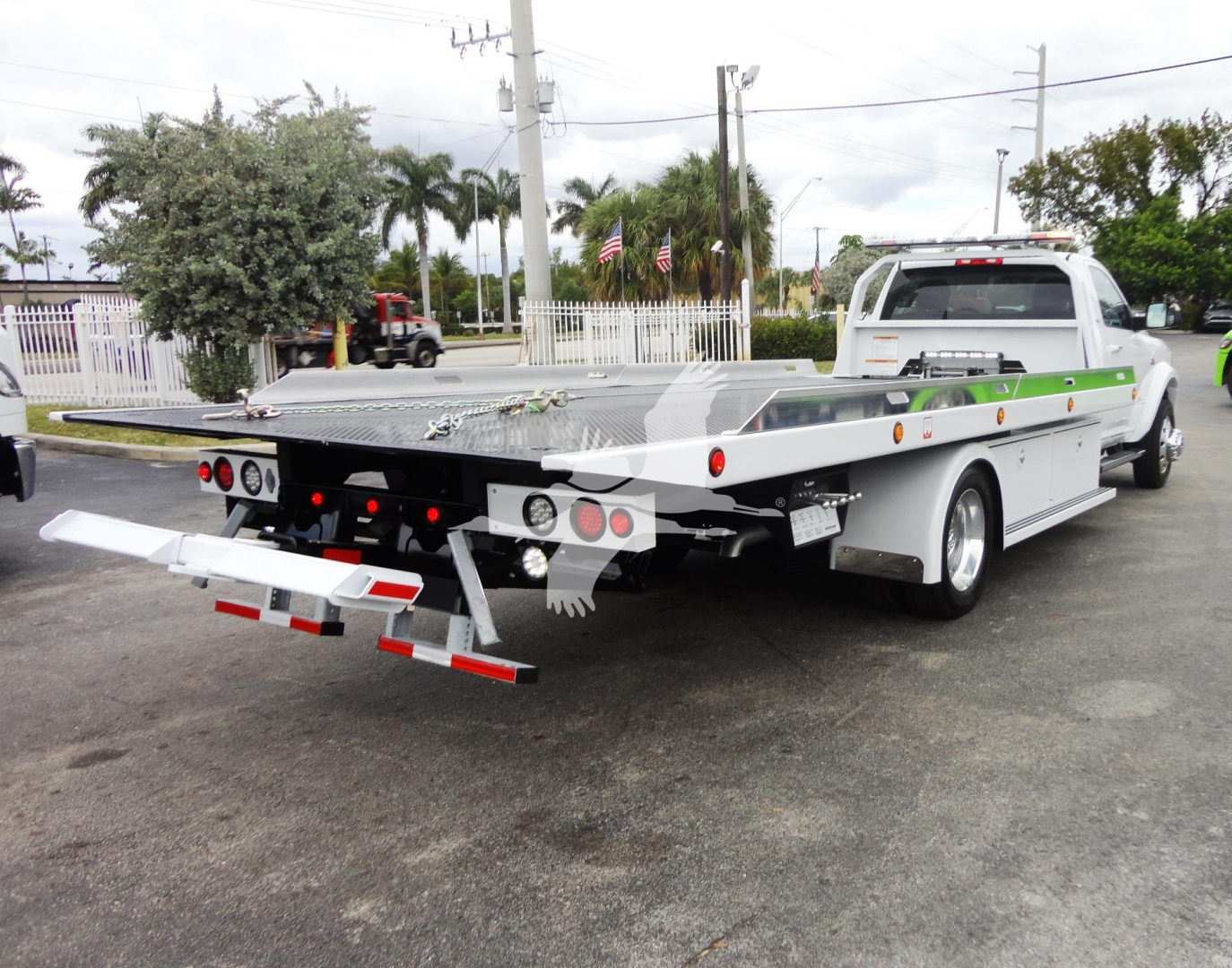 Ram 5500 rollback tow truck with flatbed showing rear view and equipment on bed