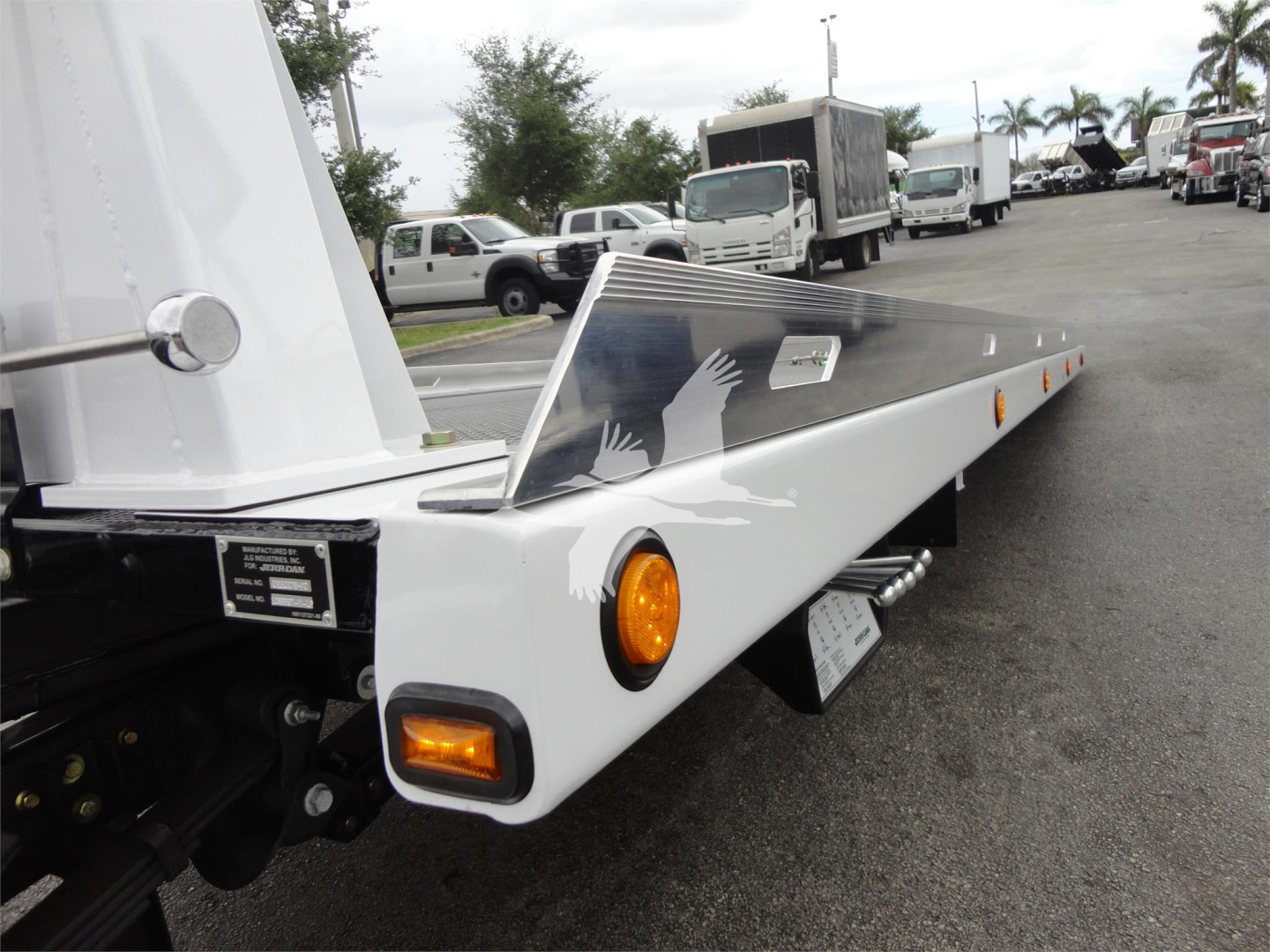 Truck flatbed with white metal, side marker light, and decorative handprint graphic. View shows ramp storage and wheel area.