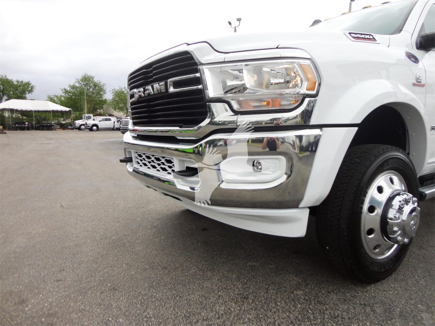 Ram 5500 front-right view showing grille, headlight, bumper, chrome trim, and wheel fender on a white pickup truck.