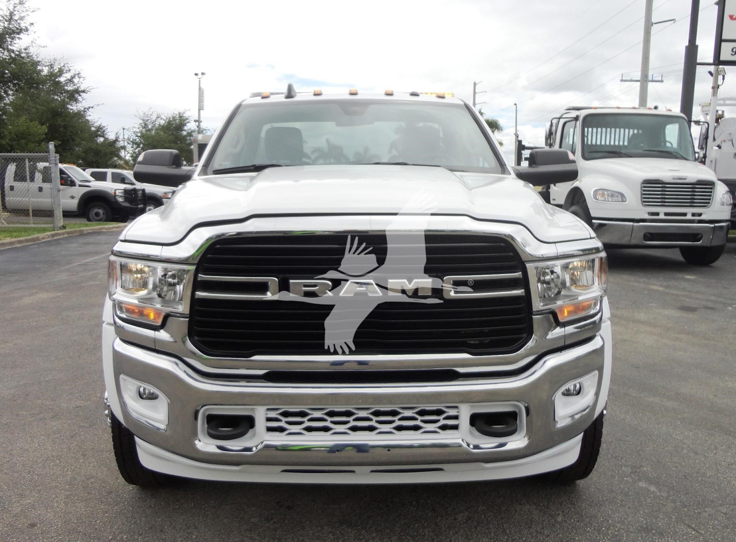 Front view of white 2023 Ram 5500 HD SLT pickup with RAM grille badge and chrome bumper.