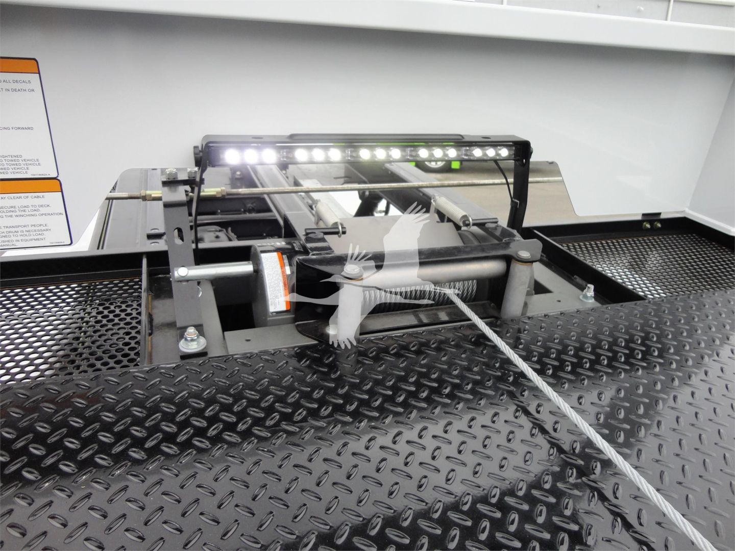 Ram 5500 truck rollback equipment mount with LED light bar and winch on metal diamond plate bed.