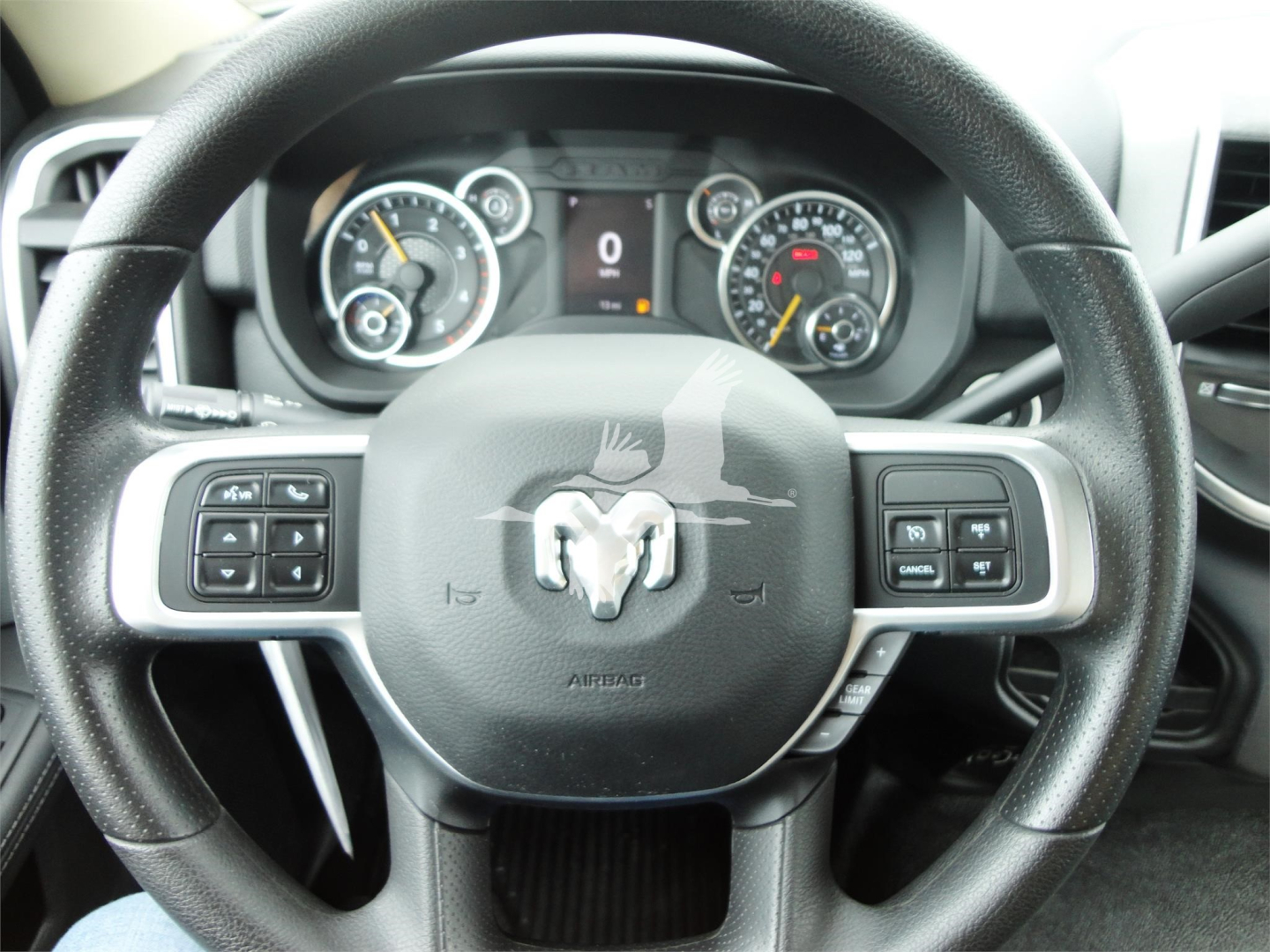 Ram 5500 HD SLT steering wheel and instrument cluster showing controls on left and right spokes and Dodge logo in center.