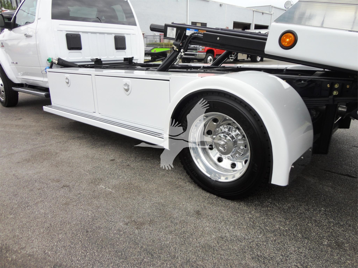 Ram 5500 Rollback utility truck side view showing white service body with storage drawers and large chrome wheel.