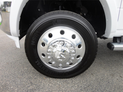 Truck wheel close-up showing chrome hubcap and Goodyear MT tire on Ram 5500 chassis cab.