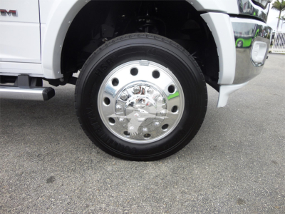 Front wheel and tire of a 2023 Ram 5500 HD SLT truck showing chrome wheel hub and tire.