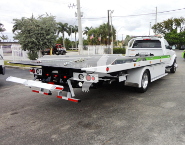Ram 5500 rollback tow truck with flatbed showing rear view and equipment on bed