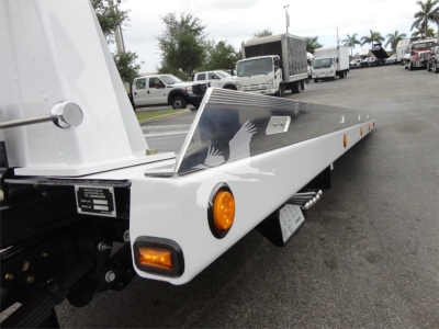 Truck flatbed with white metal, side marker light, and decorative handprint graphic. View shows ramp storage and wheel area.