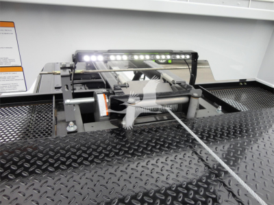 Ram 5500 truck rollback equipment mount with LED light bar and winch on metal diamond plate bed.