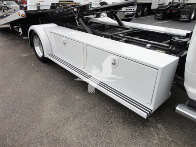 Ram 5500 rollback body side view showing storage compartments and hydraulic system mounting behind the cab.