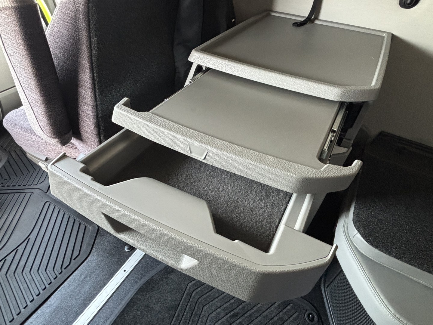 Volvo VNL64T860 truck interior storage drawers extended showing multiple compartments and gray plastic trays.
