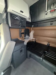 Freightliner Cascadia 126 cab interior showing sleeper area with storage cabinet and bed platform