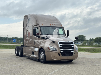 Truck front three-quarter view showing Freightliner Cascadia 126 sleeper cab with chrome grille and beige paint.