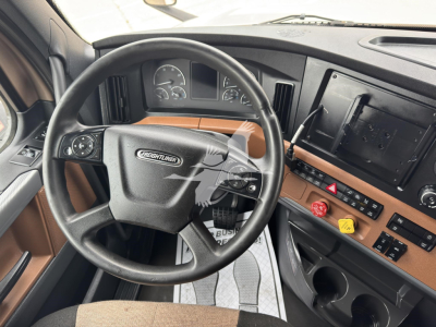 Freightliner Cascadia 126 truck interior showing steering wheel and dashboard with center console controls.