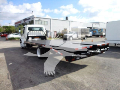 Flatbed tow truck/roll-off style Freightliner M2 106 with open flatbed tail, rear view showing long bed and hitch.