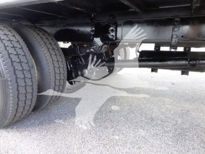 Underbody view of a Freightliner M2 106 truck showing dual rear wheels, driveshaft, suspension, and chassis components.
