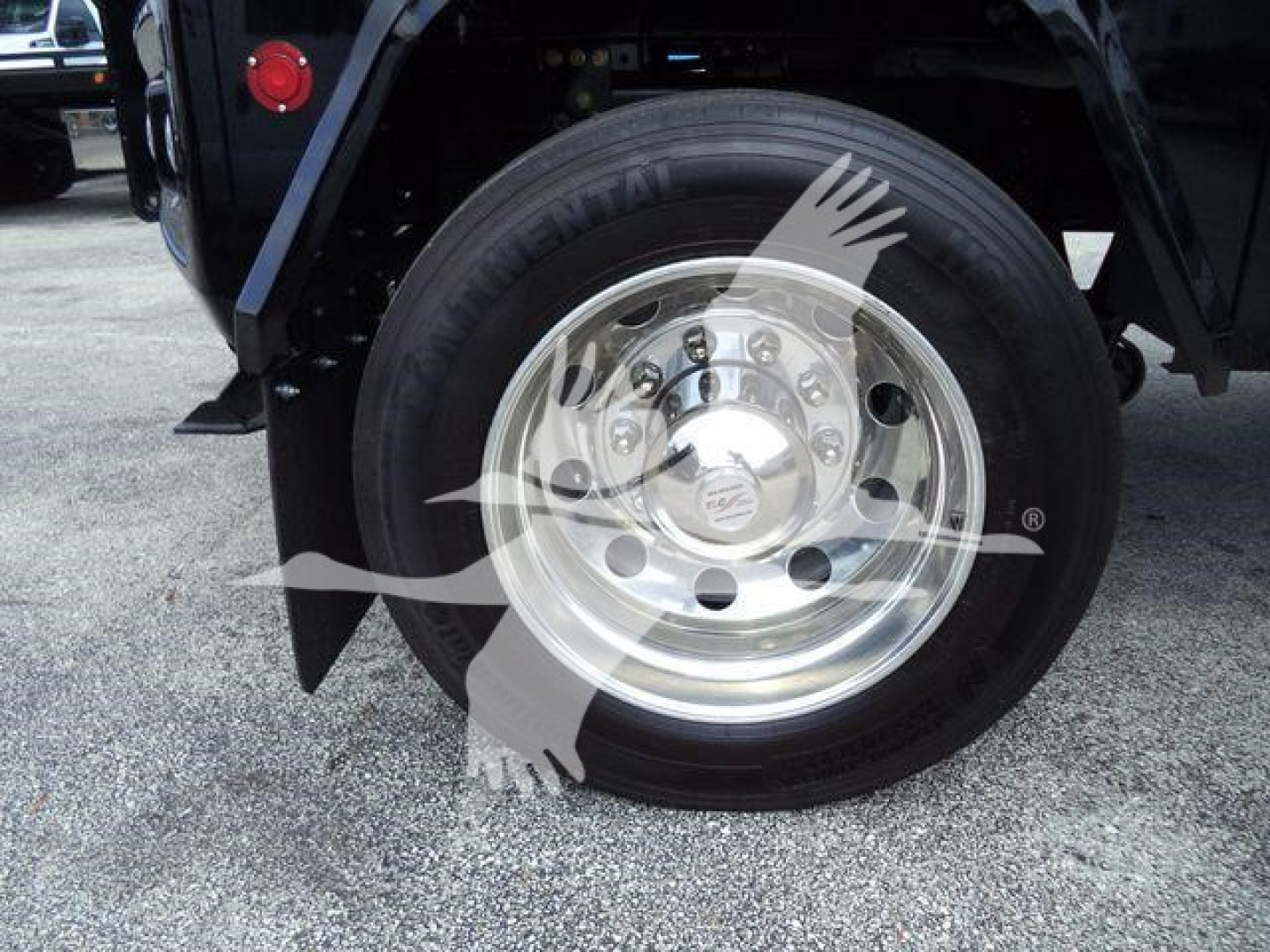 Truck wheel and tire assembly showing polished hubcap, with visible tire sidewall markings.