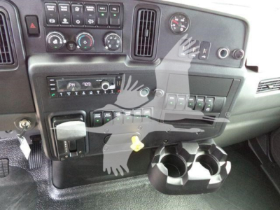 Truck dashboard showing center console with climate controls, radio, and multiple switches; cup holders and yellow ignition key visible.